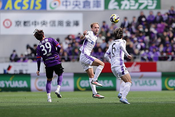 Cầu thủ Sanfrecce Hiroshima và Kyoto Sanga trong một tình huống tranh chấp bóng trên sân.